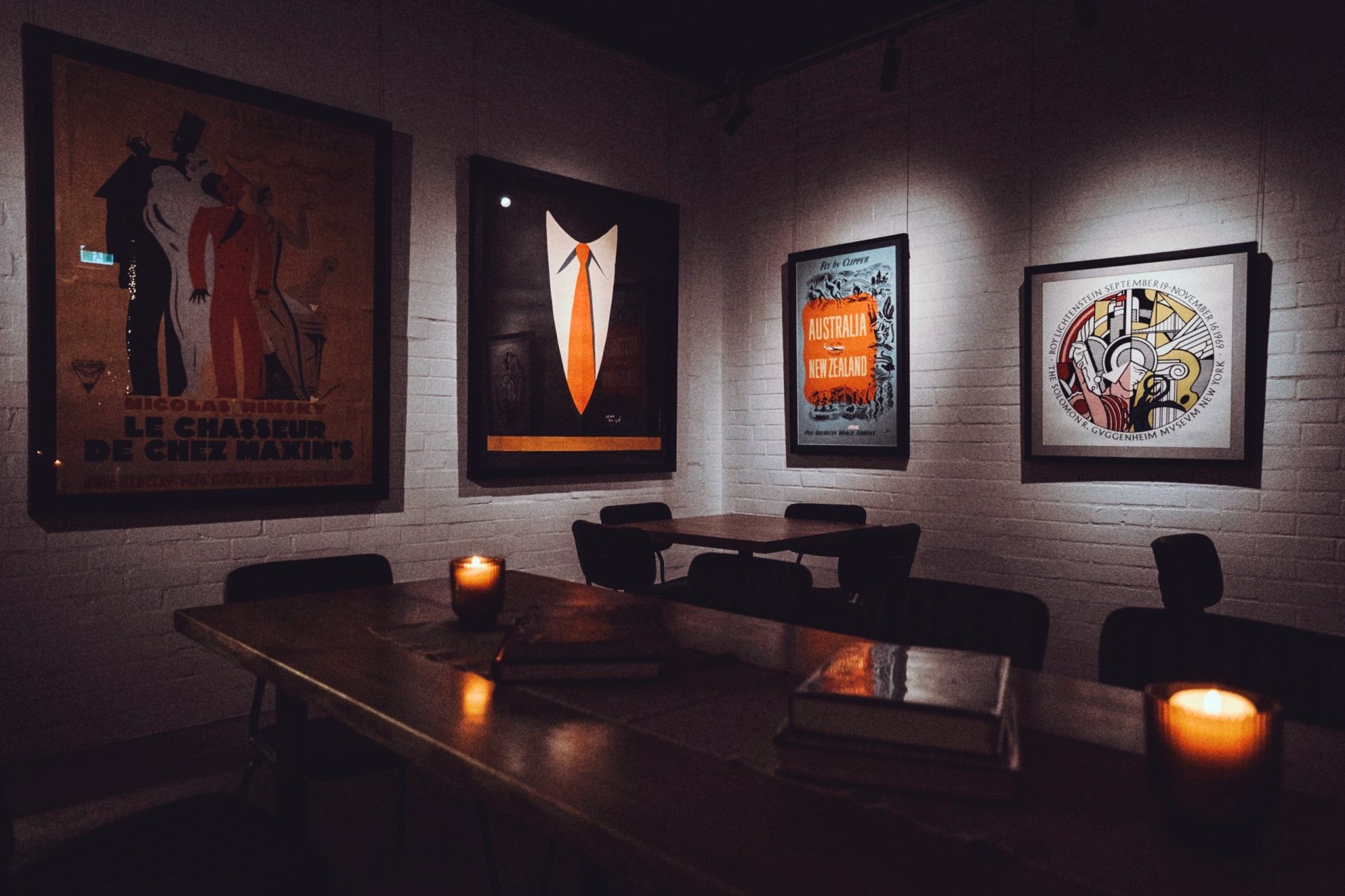 The room at night, posters lit above the table