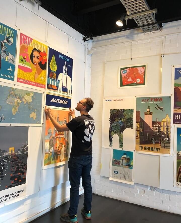 Hanging vintage travel posters in the gallery